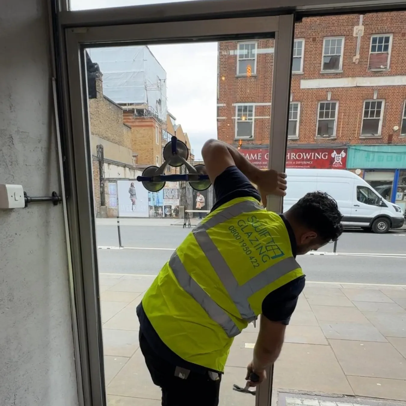 Technician working on a glass entrance door during a commercial door accessibility upgrade in Washington DC