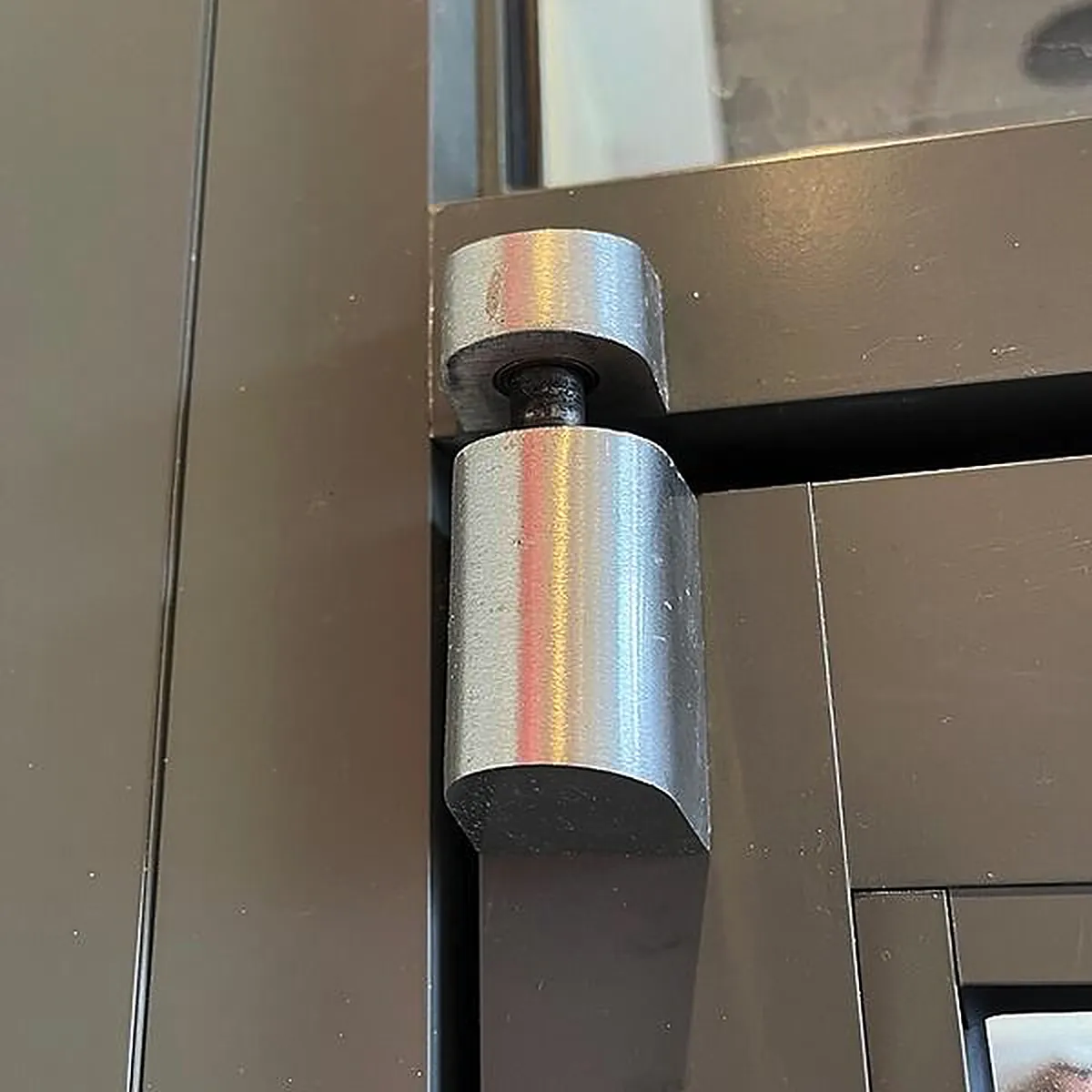 Aluminum storefront door pivot hinge close-up for commercial door pivot repair in Washington DC