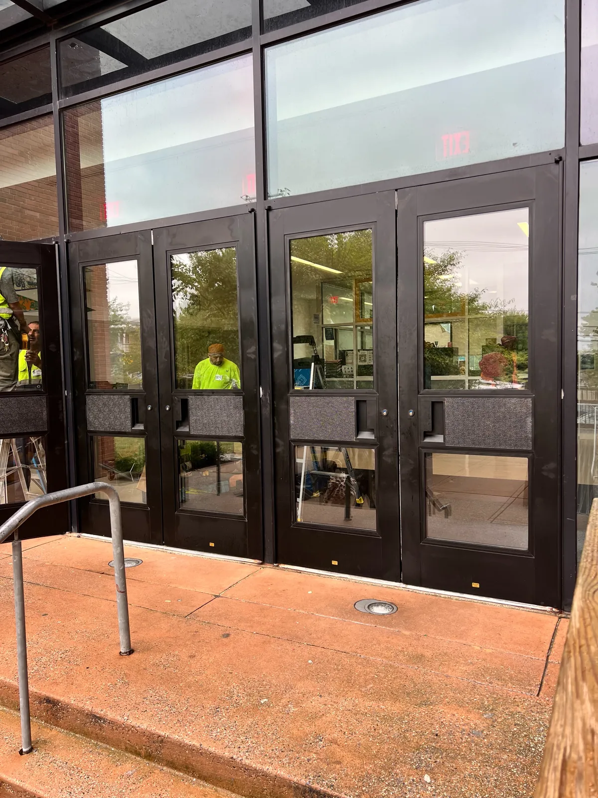 Technicians repairing commercial aluminum storefront entrance doors in Washington DC